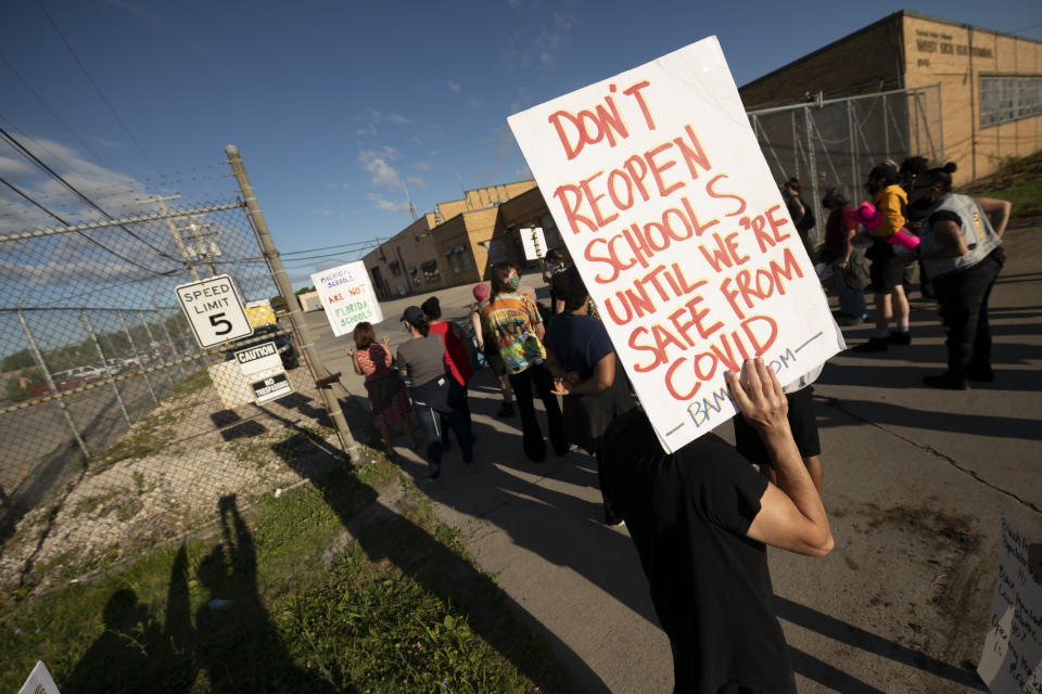 Demonstrators block the driveways of the Detroit Public Schools West Side Bus Terminal to keep school buses from running on the first day of summer school, in Detroit, Monday, July 13, 2020. Concerns about COVID-19 and a lack of safety measures prompted the protesters to demand that schools close. (David Guralnick/The Detroit News)/Detroit News via AP)