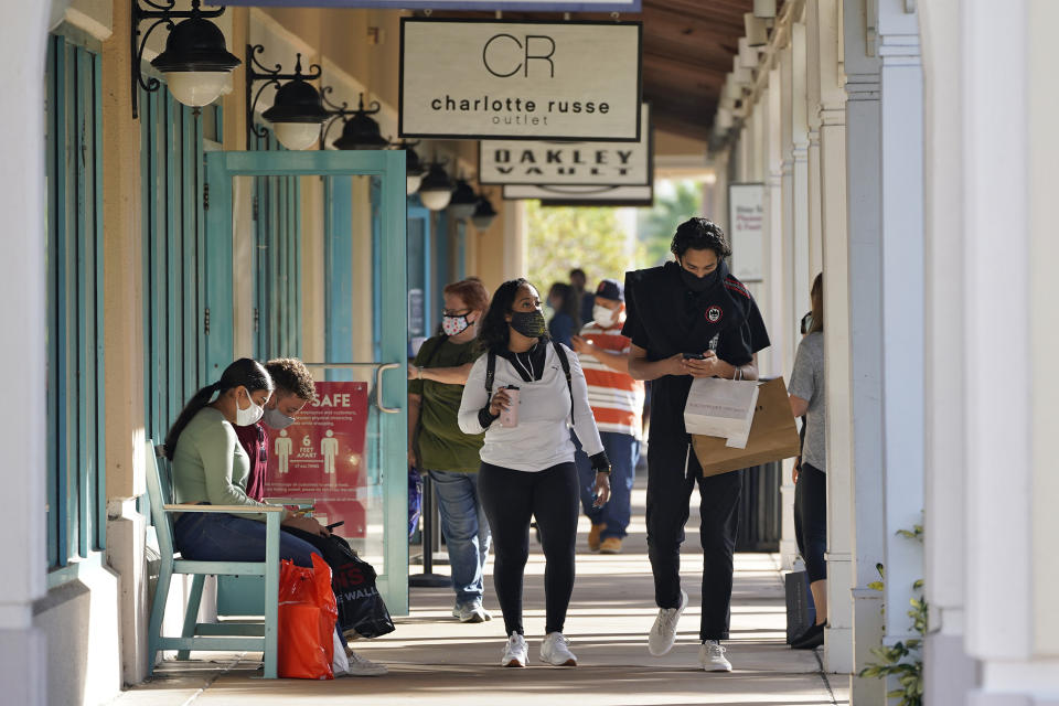 Shoppers wear protective face masks as they look for Black Friday deals at the Ellenton Premium Outlet stores in Ellenton, Fla. (AP Photo/Chris O'Meara)