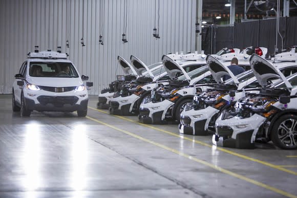 Image of GM cars with hoods open in a factory.