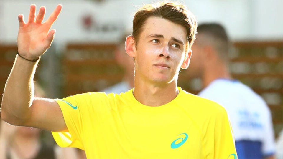 Pictured here, Alex de Minaur waves to fans after a Davis Cup match for Australia.