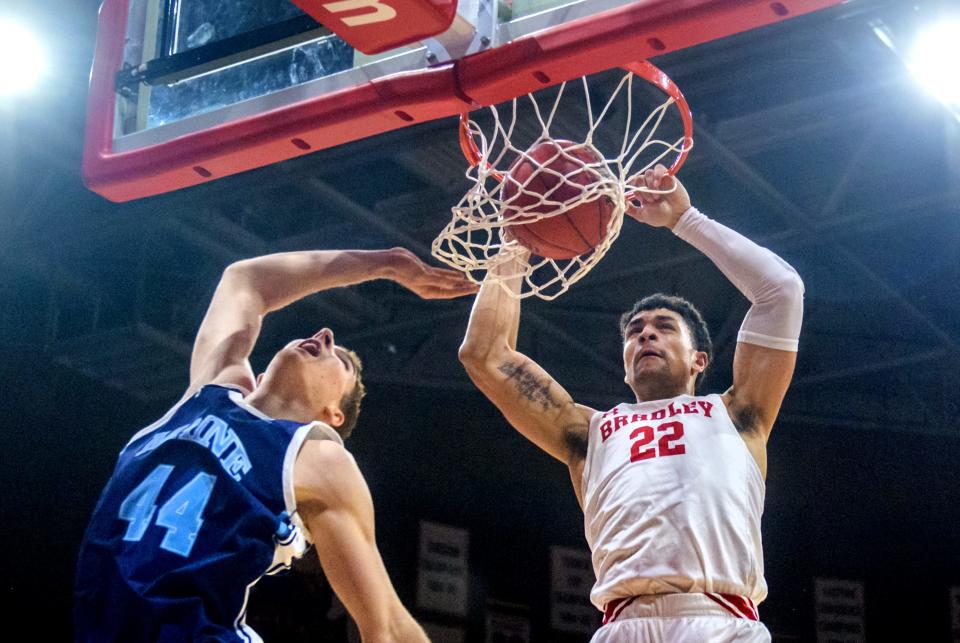 Bradley's Ja'Shon Henry, right, dunks over Maine's Peter Filipovity in the first half Saturday, Nov. 27, 2021 at Carver Arena. The Braves defeated the Black Bears 71-39.