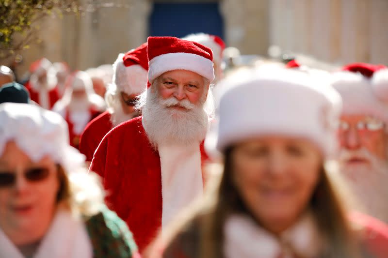 A man dressed in a Santa Claus outfit, takes part in a parade together with a group of Santa Clauses from around the world, as they tour Jerusalem's Old City