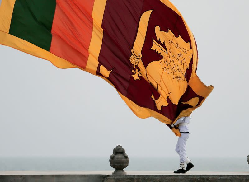 Sri Lankan military officer lowers the national flag in Colombo