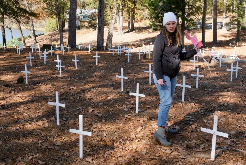 Students studying in the University of Alabama’s Anthropology Department mark graves in the Prewitt Slave Cemetery in Tuscaloosa County Tuesday, Oct. 31, 2023. MacKenzie Harless carries flags that will be used to mark graves.