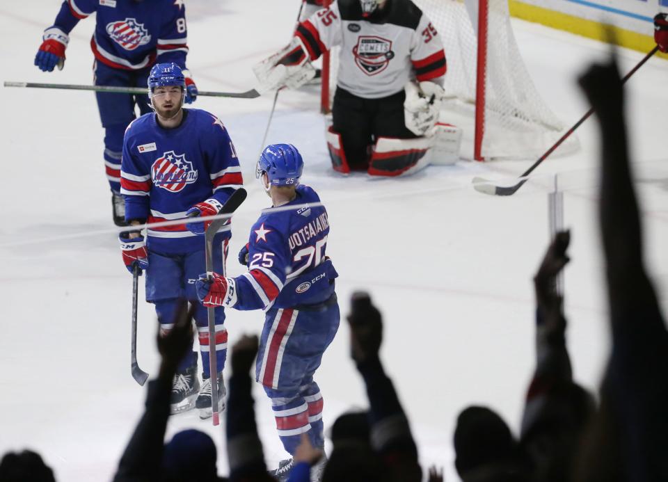 Rochester's Arttu Ruotsalainen (25), right, celebrates his third period goal with teammate Lukas Rousek during Game 4 of their North Division semifinal series Tuesday, May 17, 2022 at Blue Cross Arena.  Utica won the game 4-2.