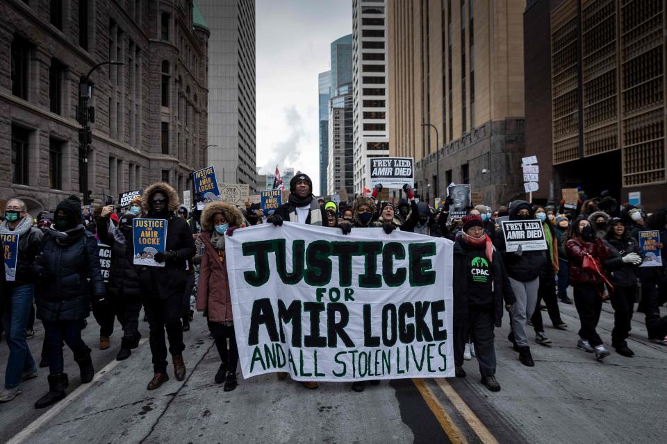 Demonstrators march behind a banner reading "Justice for Amir Locke and All Stolen Lives" during a rally in protest of the killing of Amir Locke, outside the Hennepin County Government Center in Minneapolis, Minnesota on February 5, 2022.