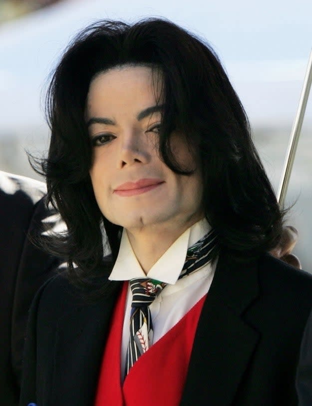 Michael Jackson in a suit with a red tie and decorative scarf