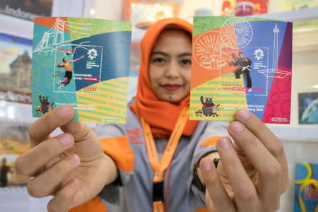 A postal worker shows special edition Asian Games 2018 stamps at a PT Pos Indonesia office in Bandung, West Java, Indonesia February 19, 2018 in this photo taken by Antara Foto. Picture taken February 19, 2018. Antara Foto/Novrian Arbi via REUTERS