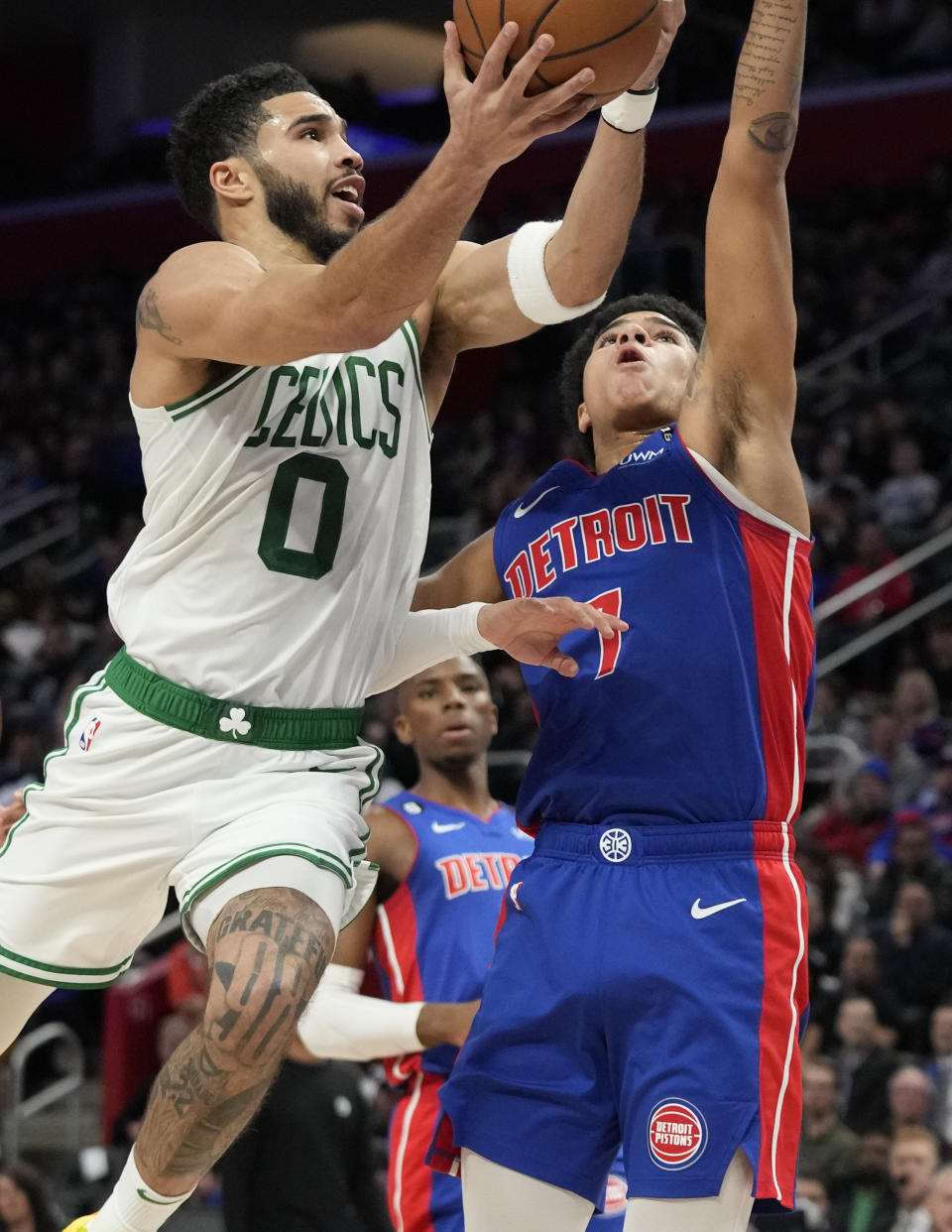 Boston Celtics forward Jayson Tatum (0) attempts a layup as Detroit Pistons guard Killian Hayes (7) defends during the first half of an NBA basketball game, Monday, Feb. 6, 2023, in Detroit. (AP Photo/Carlos Osorio)