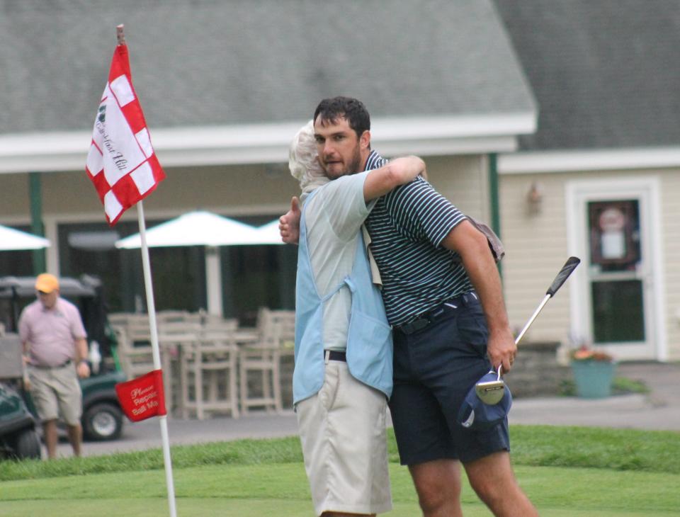 Nick McLaughlin, derecha, y su padre/caddie Bill se abrazan después del tercer campeonato de golf amateur Seacoast de Nick en el Breakfast Hill Golf Club el domingo en Groenlandia.