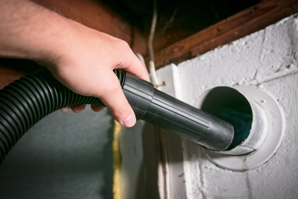 Vacuum cleaning a flexible aluminum dryer vent hose, to remove lint and prevent a fire hazard.