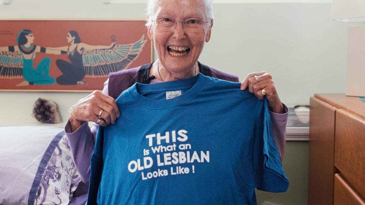 Edie Daly holds a blue t-shirt that says 