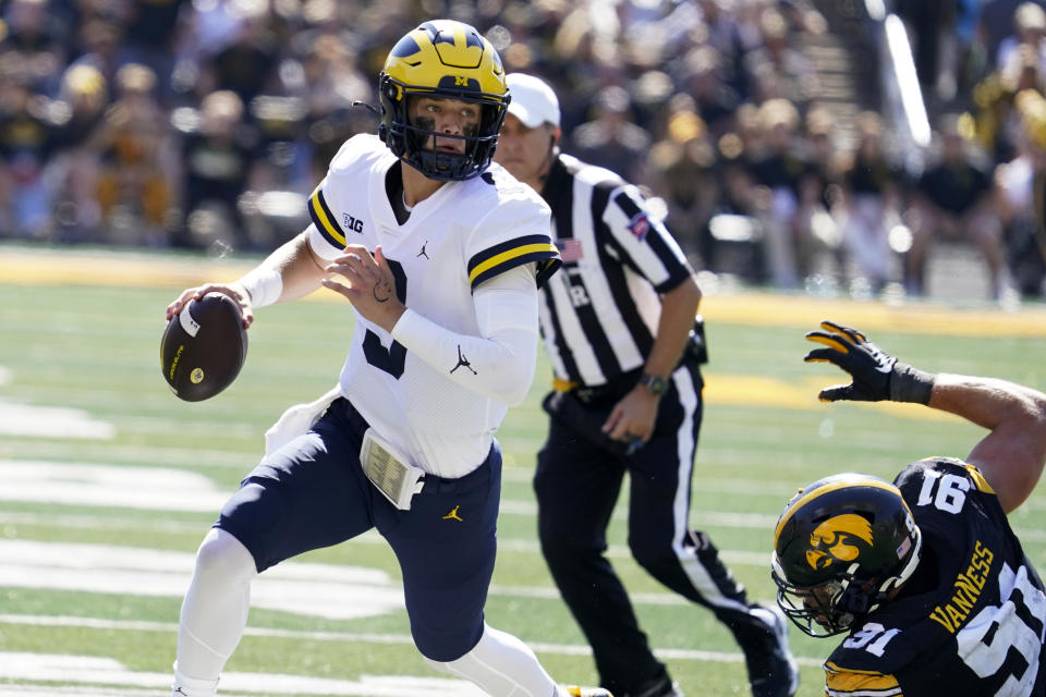 Michigan quarterback J.J. McCarthy (9) runs from Iowa defensive lineman Lukas Van Ness (91) during the second half of an NCAA college football game, Saturday, Oct. 1, 2022, in Iowa City, Iowa. Michigan won 27-14. (AP Photo/Charlie Neibergall)