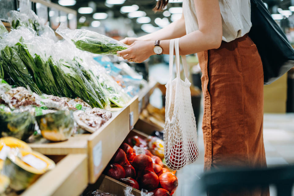 A person grocery shopping with a sustainable mesh bag