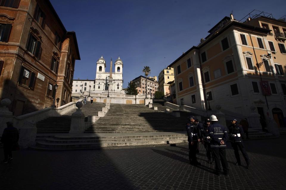 Italian municipality police stand by empty Spanish Steps, in Rome, Tuesday, March 10, 2020. Italy entered its first day under a nationwide lockdown after a government decree extended restrictions on movement from the hard-hit north to the rest of the country to prevent the spreading of coronavirus. (AP Photo/Andrew Medichini)