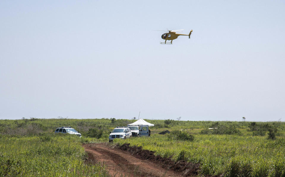 This Thursday, Feb. 27, 2014 photo released by Russell deJetley shows a helicopter fly over the site of a plane crash in Lanai City, Hawaii. A small plane crashed and burst into flames shortly after takeoff from Hawaii's Lanai island, killing three people and leaving three others injured, authorities said Thursday. The crash occurred around 9:30 p.m. Wednesday about a mile from Lanai Airport in the Miki Basin area, Maui County spokesman Rod Antone told The Associated Press. (AP Photo/Russell deJetley)