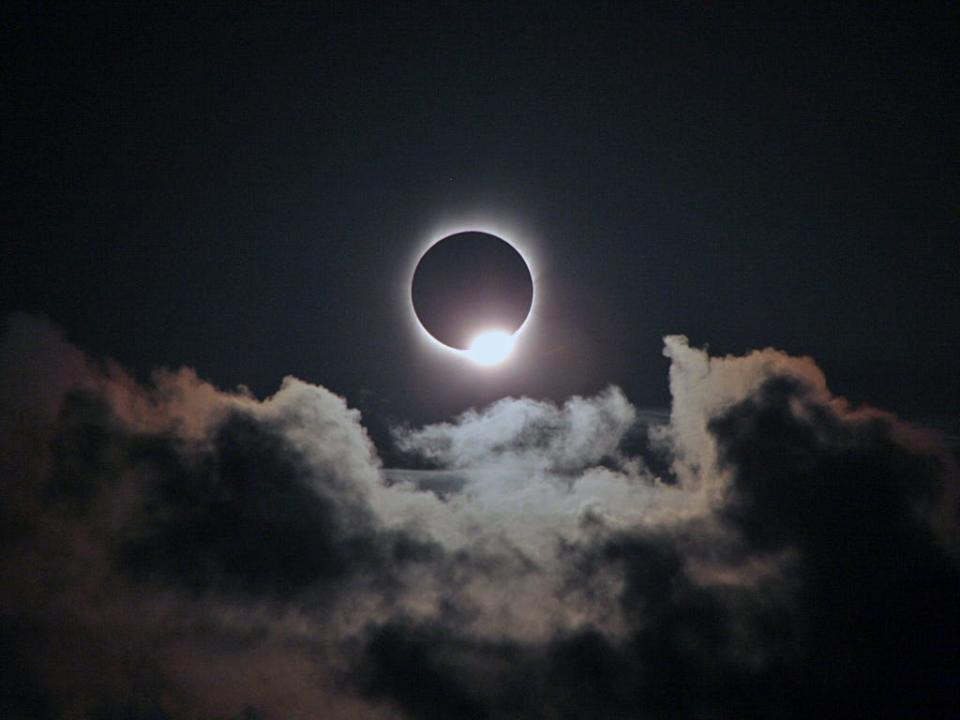 The diamond ring effect appears during a total solar eclipse as a bright diamond of light on the edge of the moon as it moves across the sun.