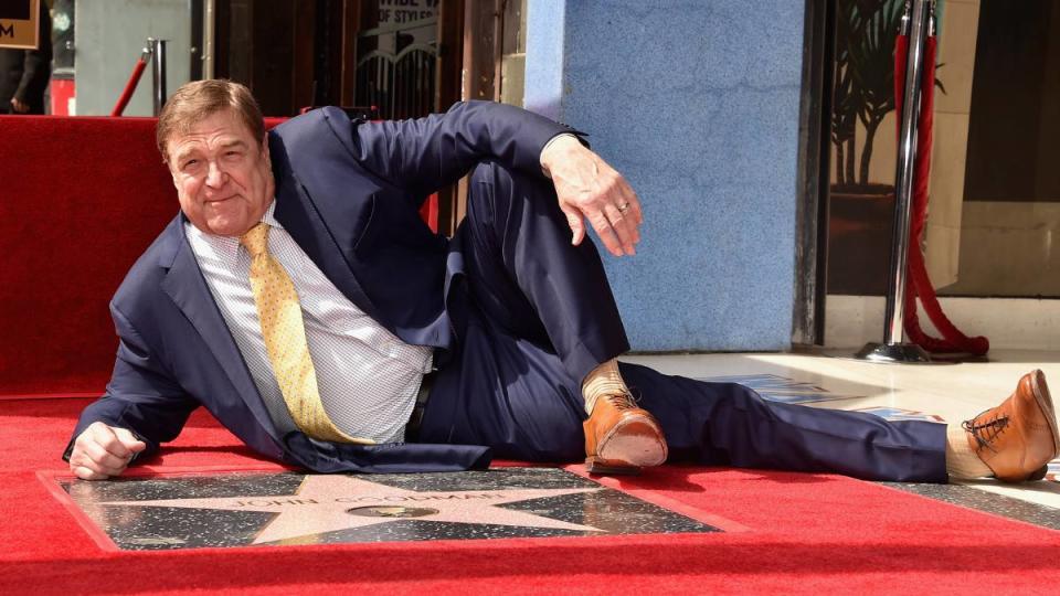 man laying posed on Hollywood walk of fame; john goodman movies and tv shows