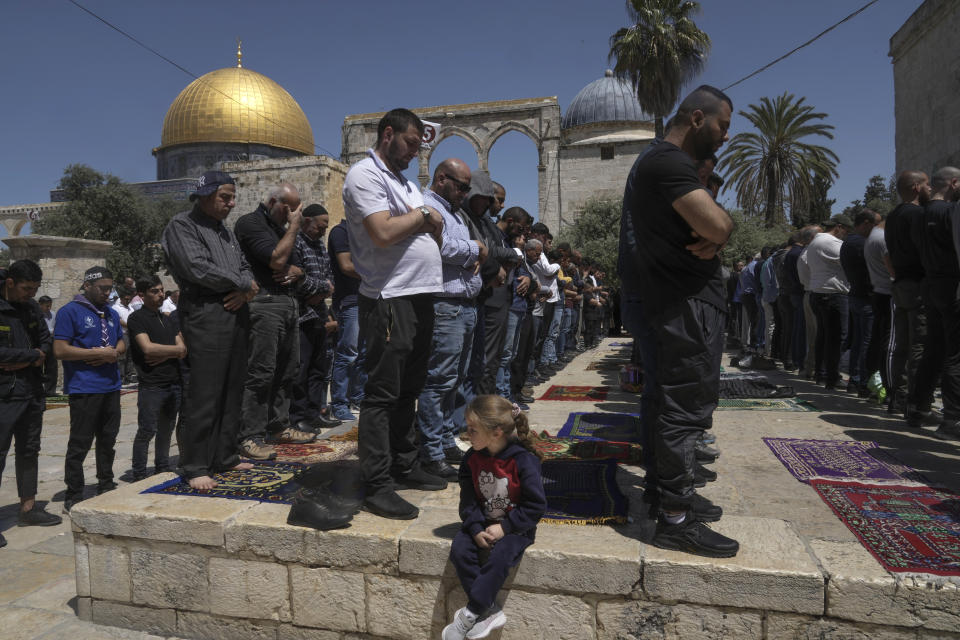 Palestinian men pray on the second Friday of the holy Islamic month of Ramadan in front of the Dome of the Rock shrine at the Al Aqsa Mosque compound in Jerusalem's Old City, Friday, April 15, 2022. Palestinians clashed with Israeli police at the Al-Aqsa mosque compound in Jerusalem before dawn on Friday as thousands gathered for prayers during the holy month of Ramadan. Medics said that more than 150 Palestinians were wounded. (AP Photo/Mahmoud Illean)