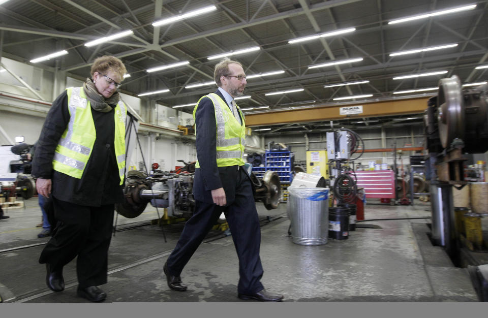 In this photo taken, Wednesday, Aril 11, 2012, Federal Transit Administrator Peter Rogoff, right, and Bay Area Rapid Transit (BART) General Manager Grace Crunican walk through a work area during a tour of the BART Maintenance Yard in Hayward, Calif. Driven by high gas prices and an uncertain economy, Americans are turning to trains and buses to get around in greater numbers than ever before. The aging trains and buses they’re riding, however, face an $80 billion maintenance backlog that jeopardizes service just when it’s most in demand. (AP Photo/Jeff Chiu)