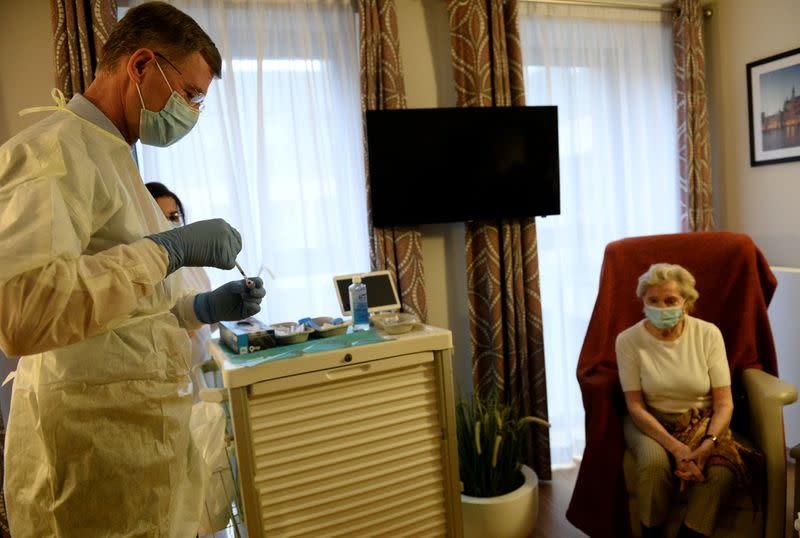 Lucie Vandamme receives a dose of the Pfizer-BioNTech COVID-19 vaccine at Prince Royal home care in Brussels