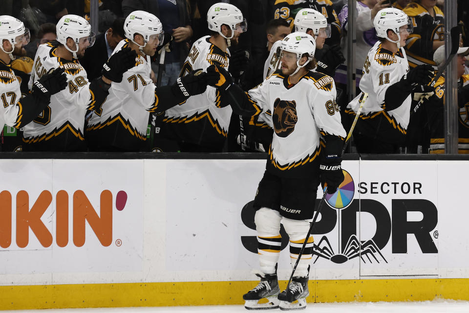 Boston Bruins' David Pastrnak is congratulated at the bench after scoring against the Colorado Avalanche during the first period of an NHL hockey game Saturday, Dec. 3, 2022, in Boston. (AP Photo/Winslow Townson)