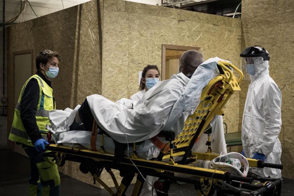 Ambulance crew work as a patient arrives at the CHR CItadelle hospital in Liege, Belgium, Thursday, Oct. 29, 2020. Belgium has announced restrictive measures across the country in an effort to curb the fast-rising tide of COVID-19, coronavirus cases. (AP Photo/Valentin Bianchi)