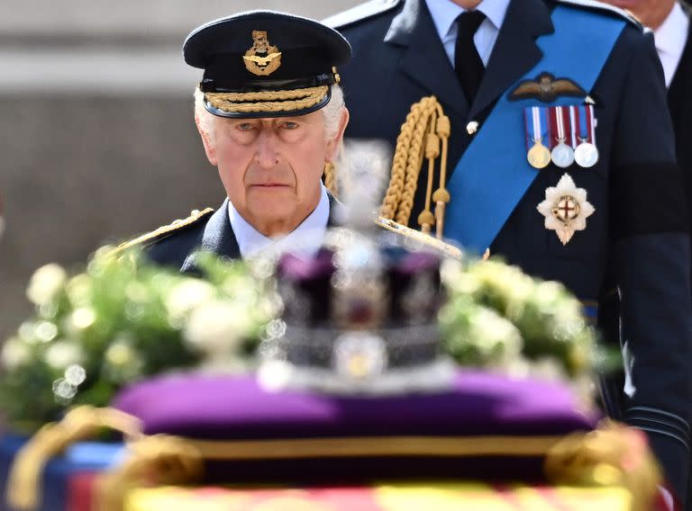 En esta foto de archivo tomada el 14 de septiembre de 2022, el Rey Carlos III de Gran Bretaña camina detrás del féretro de la Reina Isabel II, adornado con un Estandarte Real y la Corona Imperial de Estado y tirado por un Carruaje de Artillería de la Tropa del Rey de la Artillería Real a Caballo, durante una procesión desde el Palacio de Buckingham hasta el Palacio de Westminster, en Londres