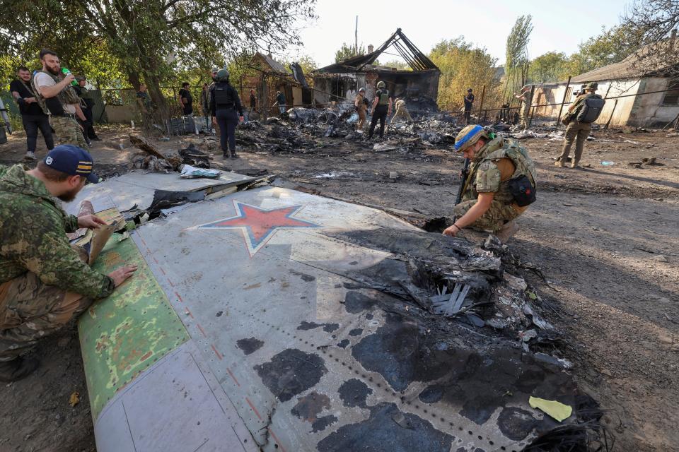 Ukrainian soldiers inspect parts of a Russian S-70 drone in eastern Ukraine on October 5.