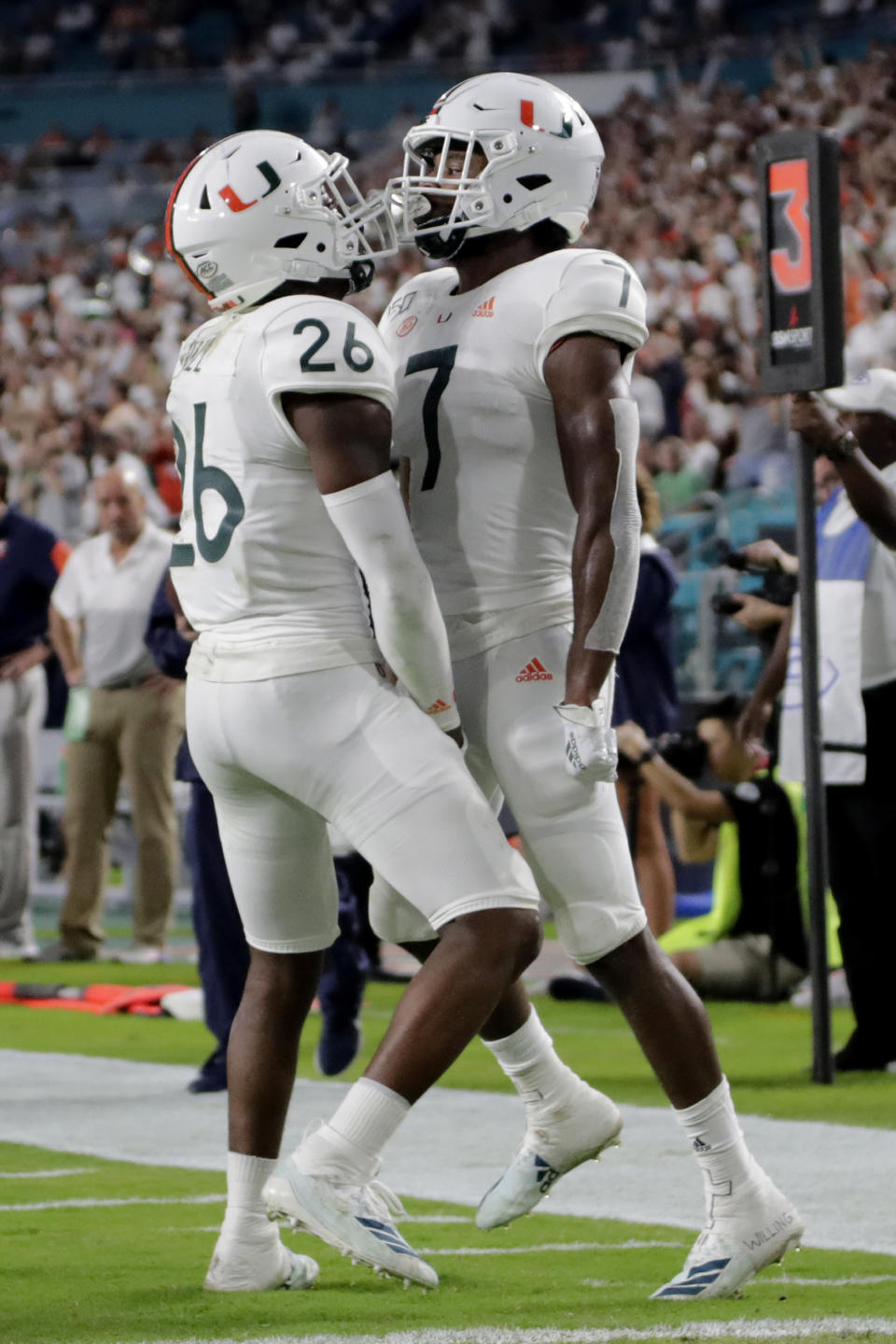 Miami cornerback Al Blades Jr. (7) celebrates with defensive back Gurvan Hall Jr. (26) after breaking up a pass intended for Virginia wide receiver Terrell Chatman during the first half of an NCAA college football game, Friday, Oct. 11, 2019, in Miami Gardens, Fla. (AP Photo/Lynne Sladky)