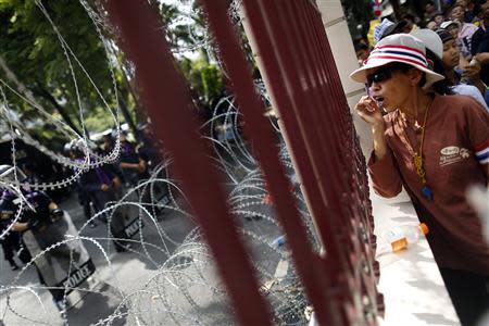 An anti-government protester shouts at policemen guarding the national police headquarters as protesters gather outside its compound in Bangkok November 28, 2013. REUTERS/Damir Sagolj