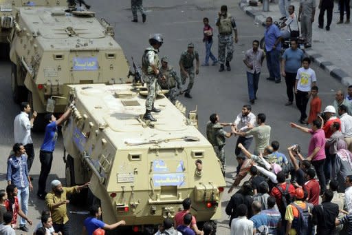 An Egyptian anti-military protester confronts an army officer following the deployment of a military unit in the Abbassiya district of Cairo