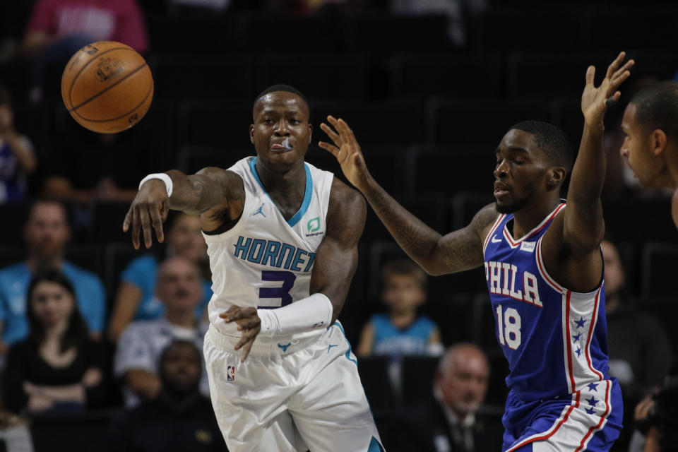 Charlotte Hornets guard Terry Rozier III, left, passes around Philadelphia 76ers guard Shake Milton in the first half of a preseason NBA basketball game in Winston-Salem, N.C., Friday, Oct. 11, 2019. (AP Photo/Nell Redmond)