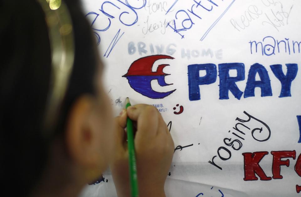 A child leaves a message of support for family members and passengers onboard the missing Malaysia Airlines Flight MH370 in Sepang