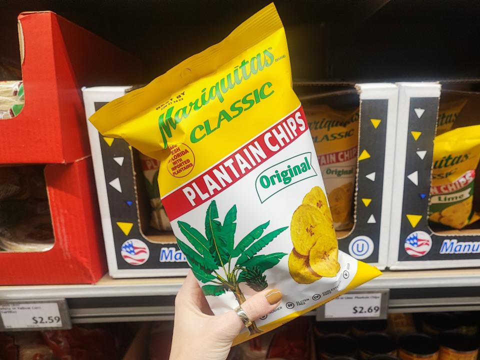 A hand holding a bag of Mariquitas Classic plantain chips.