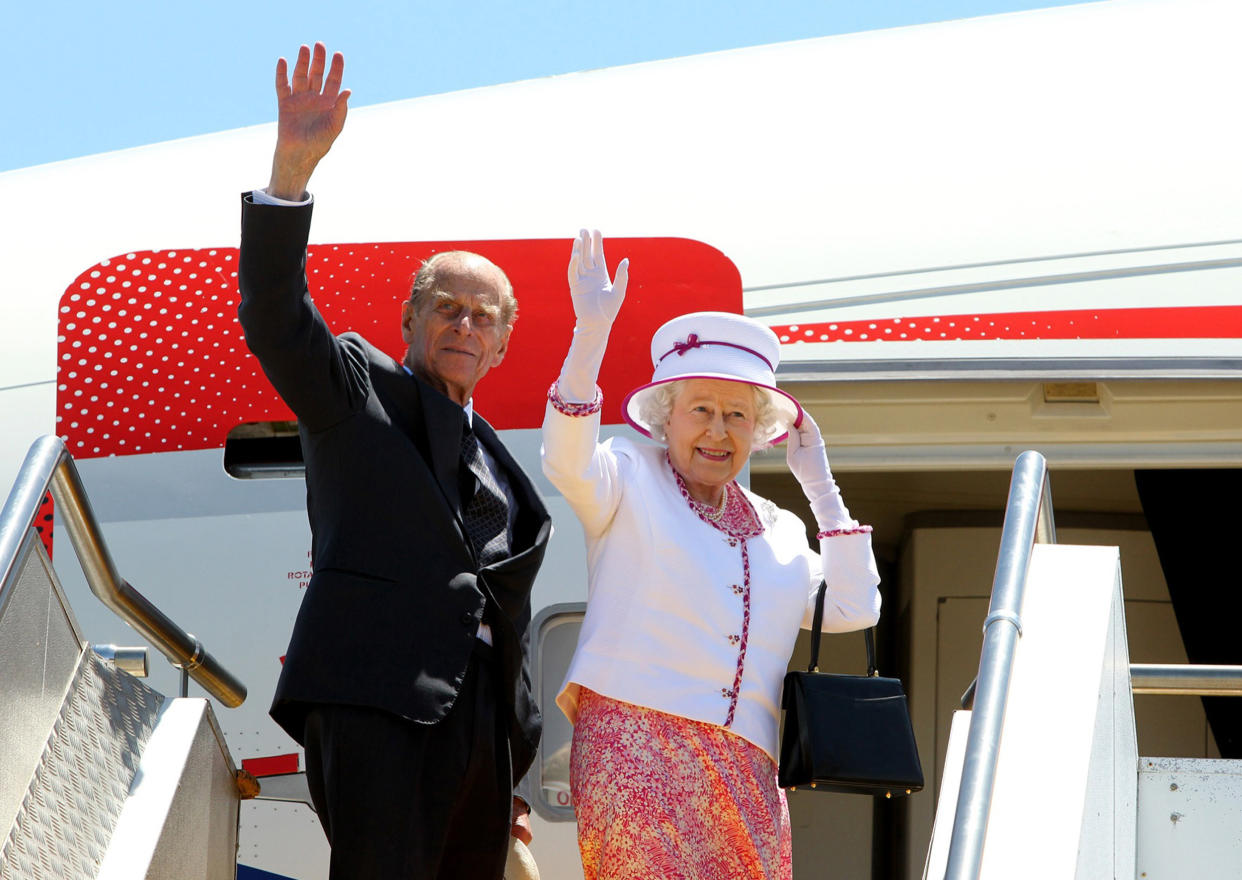 Britain's Queen Elizabeth II (R) and Prince Philip wave goodbye as they board their flight at Perth International Airport following their 10-day visit to Australia on October 29, 2011. The queen wrapped up an immensely successful tour of Australia in which tens of thousands flocked to catch a glimpse of their monarch, perhaps for the last time.     AFP PHOTO / POOL / Lincoln Baker (Photo credit should read LINCOLN BAKER/AFP via Getty Images)