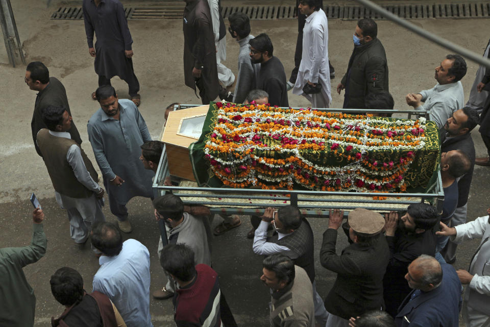 People carries the coffin of a victim of Friday's suicide bombing in Peshawar, Pakistan, Saturday, March 5, 2022. The Islamic State says a lone Afghan suicide bomber struck inside a Shiite Muslim mosque in Pakistan's northwestern city of Peshawar during Friday prayers, killing dozens worshippers and wounding more than 190 people. (AP Photo/Muhammas Sajjad)
