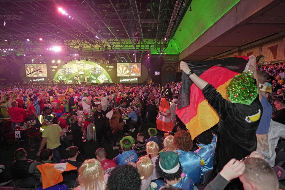 Darts fans celebrate on day eight of the World Darts Championship, at Alexandra palace in London, Friday, Dec. 22, 2023. (AP Photo/Kin Cheung)