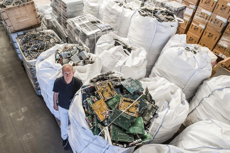 In this photo taken on July 13, 2018, founder of the company, Out Of Use, Mark Adriaenssens, stands among bags of electronic parts and components to be recycled at his warehouse in Beringen, Belgium. European Union nations are expected to produce more than 12 million tons of electronic waste per year by 2020, putting the Out Of Use company at the front of an expanding market, recuperating raw materials from electronic waste. (AP Photo/Geert Vanden Wijngaert)