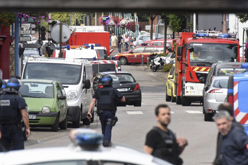 <p>Police and rescue workers stand at the scene after two assailants had taken five people hostage in the church at Saint-Etienne-du -Rouvray near Rouen in Normandy, France, July 26, 2016. (REUTERS/Steve Bonet)</p>