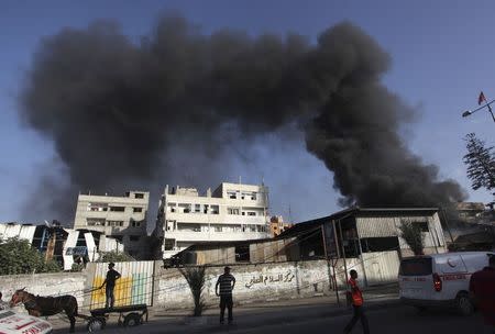 Smoke rises following what witnesses said were Israeli shelling and air strike near a market in Shejaia in the east of Gaza City July 30, 2014. REUTERS/Ashraf Amrah