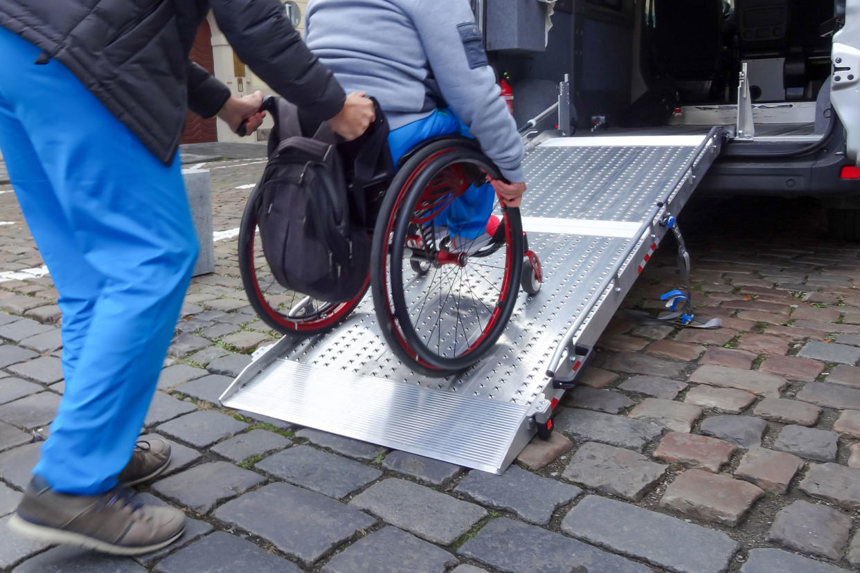 Disabled person on wheelchair using car lift Getty Images/24K-Production