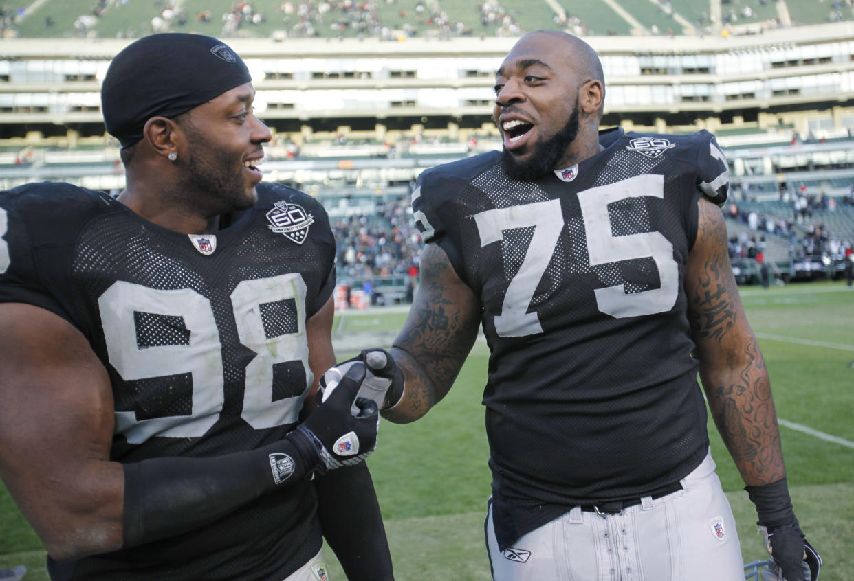 Oakland Raiders defensive end Jay Richardson (98) and offensive tackle Mario Henderson (75) celebrate after the Oakland Raiders upset the Cincinnati Bengals 20-17 in an NFL football game, in Oakland, Sunday, Nov. 22, 2009. (AP Photo/Paul Sakuma)