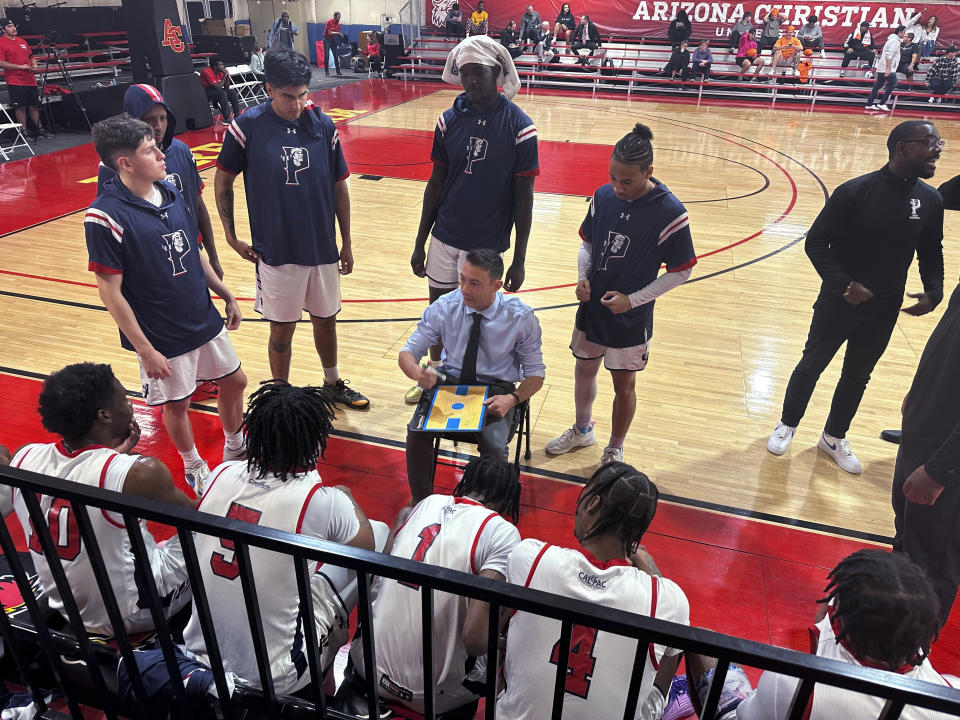 Antelope Valley coach Jordan Mast talks with his team during a timeout during a first-round game against Huntington (Indiana) in the NAIA men's basketball tournament Friday, March 15, 2024, in Glendale, Ariz. Antelope Valley lost 85-71 to end the season with a 26-5 record. Now they'll head back to California with no college to return to, but with their heads held high after the group persevered through a few uncertain months. (AP Photo/David Brandt)