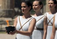 A priestess carries the Olympic Flame during the dress rehearsal for the Olympic flame lighting ceremony for the Rio 2016 Olympic Games at the site of ancient Olympia in Greece, April 20, 2016. REUTERS/Yannis Behrakis
