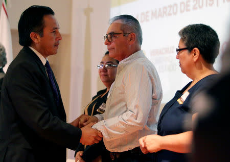 Governor Cuitlahuac Garcia Jimenez (L) offers an apology to relatives of five youths killed in 2016 after police kidnapped them and then turned them over to members of a drug gang, during a public apology by the Veracruz state government, in Mexico City, Mexico March 4, 2019. REUTERS/Daniel Becerril