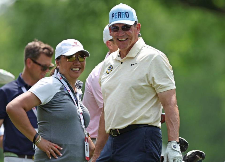 Former NFL head coach Ron Rivera, right, and his wife Stephanie, left, laugh while waiting to walk down the 11th fairway during the Wells Fargo Championship Pro-Am at Quail Hollow Club on Wednesday, May 8, 2024.