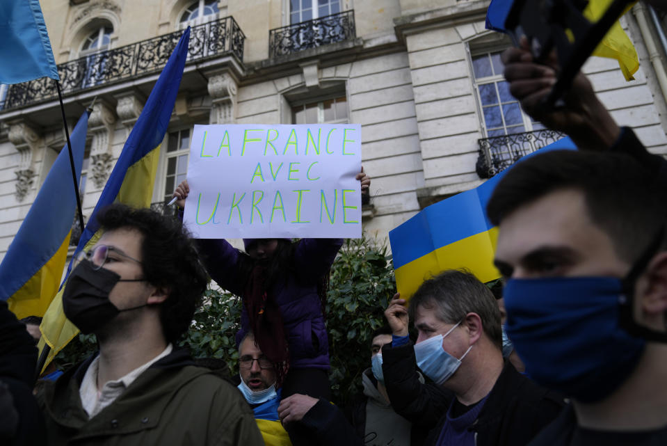 A protestor holds up a sign which reads "France is with Ukraine" during a demonstration in front of the Russian embassy in Paris, France, Tuesday, Feb. 22, 2022. World leaders are getting over the shock of Russian President Vladimir Putin ordering his forces into separatist regions of Ukraine and they are focusing on producing as forceful a reaction as possible. Germany made the first big move Tuesday and took steps to halt the process of certifying the Nord Stream 2 gas pipeline from Russia. (AP Photo/Francois Mori)
