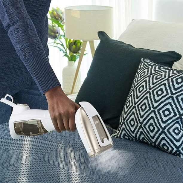 A model uses the steamer to press out wrinkles on a blanket