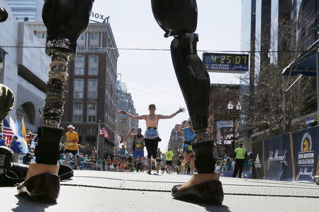 Celeste Corcoran, who lost both her legs in the Boston Marathon bombings, greets runners at they finish the 120th running of the Boston Marathon in Boston, Massachusetts April 18, 2016. REUTERS/Brian Snyder